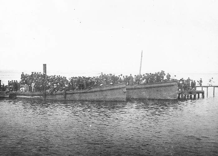Japanese contract workers disembarking off shuttle boats in Honolulu Harbor (1893).